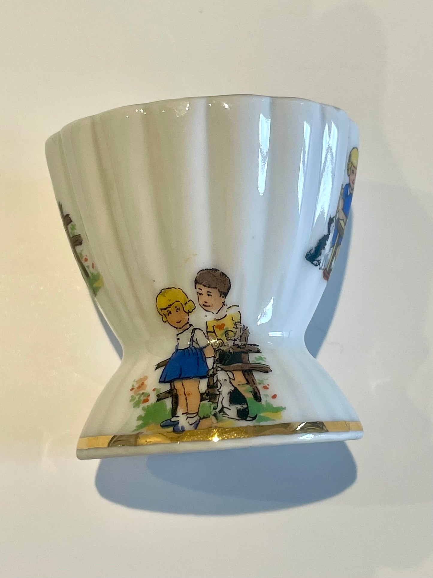 Coquetier en porcelaine de Limoges au décors enfantins